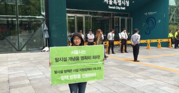매일 매일 #서울시청 앞에서 #서울시가 잘못된 정책을 폐기하고, 명확한 #탈시설개념 으로 #탈시설5개년계획 을 이행할것을 촉구하는 #1인시위 가 진행되고 있습니다. 다들 익히 알고계시죠? 오늘은 #장애와인권발바닥행동 의 미소활동가가 진행 중이었는데요. 미소활동가가 첫번째 사진의 장소에서 1인 시위하다 #불법 이라며 남성 청원경찰 4명에게 붙잡혀 두번째 사진쪽으로 질질질 끌려나왔습니다. 이게 대체 무슨 일인가요? 서울시청엔 시민이 접근할 수 없는 투명대문